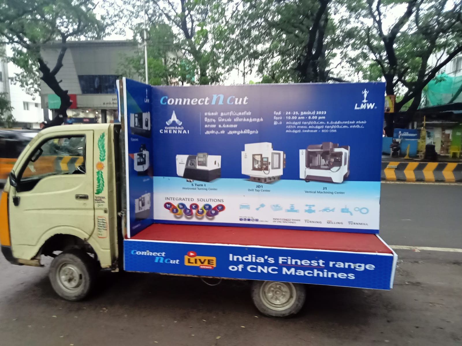 Branded advertising van near a Navratri garba ground on SG Highway in Ahmedabad at night