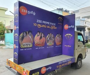 Heritage-compliant advertising van with Hindi-primary artwork on MI Road near the Pink City walled zone in Jaipur
